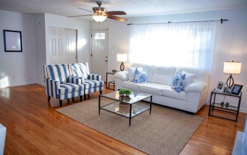 a living room with a white couch and two chairs at Cozy 3 Bedroom Home in Reynoldsburg