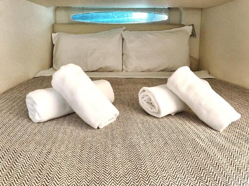 three white pillows on a bed in a room at CRUISE BY PORTO RAFTI in Porto Rafti