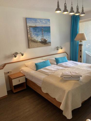 キュールングスボルンにあるFerienwohnung Yachthafentraumのベッドルーム(青い枕の大型ベッド1台付)