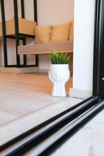a plant in a white vase sitting on a porch at Anassa Suites in Himare