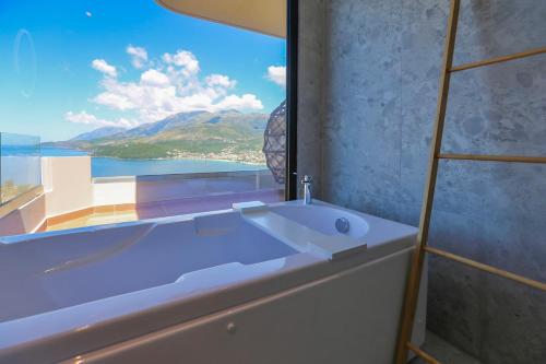 a bathroom with a bath tub with a large window at Anassa Suites in Himare