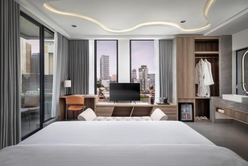 a bedroom with a large white bed and a large window at Chaiya Palace Hotel in Phnom Penh