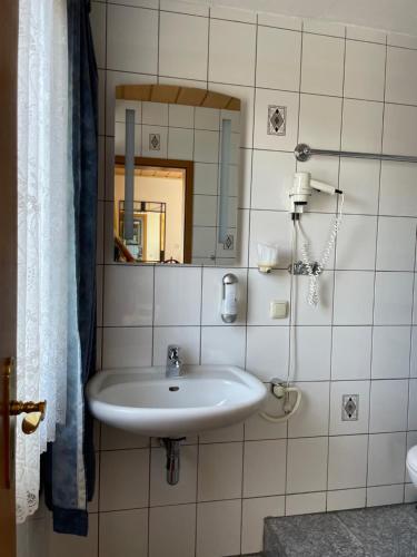 a bathroom with a white sink and a mirror at Hotel Schäfer in Siegen