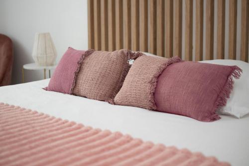 un grupo de almohadas moradas en una cama en Le Cosy - Centre Ville - 2 pièces, en Beauvais