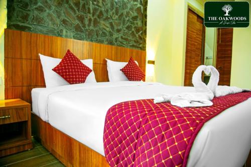 Una habitación de hotel con una cama con toallas. en The Oakwoods, en Bhowāli