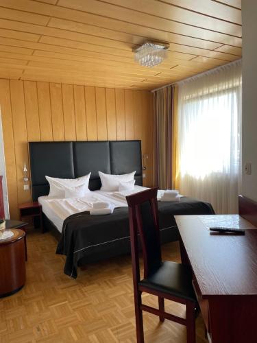 a bedroom with two beds and a table and a chair at Hotel Schäfer in Siegen