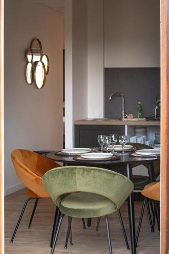 a dining room with a table with a green chair at Hôtel Restaurant Le Fiacre à Quend plage in Quend