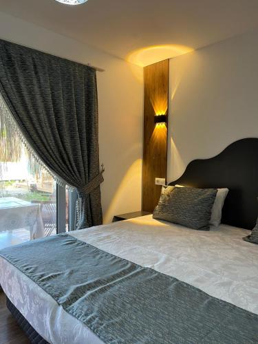 a bedroom with a bed and a large window at Karaağaç Bungalov & Tiny House in Hatay