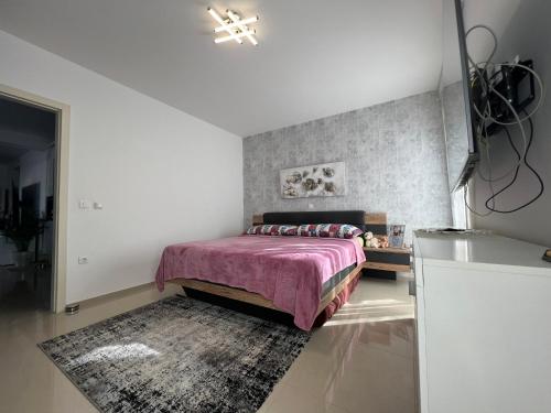 - une chambre avec un lit doté d'une couverture rose et d'un tapis dans l'établissement Apartment Lena, à Medulin