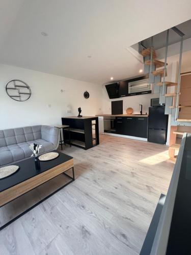 una sala de estar con un sofá y una mesa en La pause bretonne, en Quimperlé