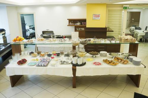una mesa con muchos tipos diferentes de comida en ella en Hotel Europa, en Reggio Emilia