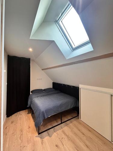 une chambre avec un lit et une lucarne dans l'établissement La pause bretonne, à Quimperlé