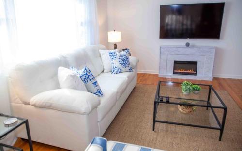 a living room with a white couch and a fireplace at Cozy 3 Bedroom Home in Reynoldsburg