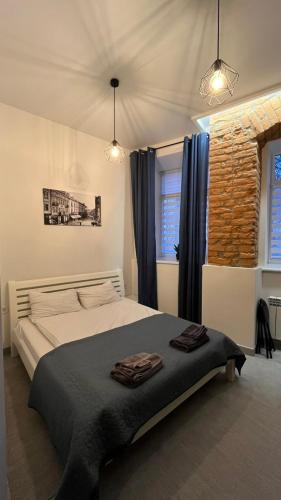 a bedroom with a bed with two towels on it at St Benedict Apartments in Lviv