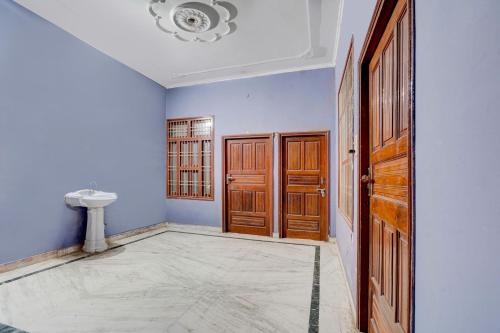 a bathroom with blue walls and wooden doors at OYO Crown Food Court cfc in Charkhi Dādri