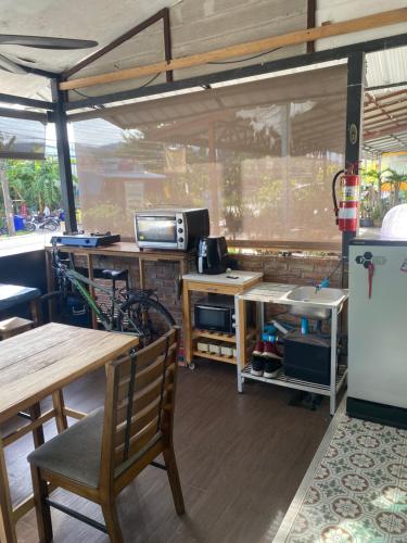 a room with a table and a refrigerator and a table and chairs at English owned Homestay and Yoga in Chalong 