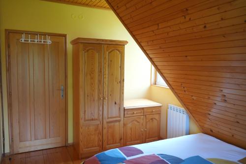 a bedroom with a bed and a wooden ceiling at Vila Zeleno borje in Žabljak