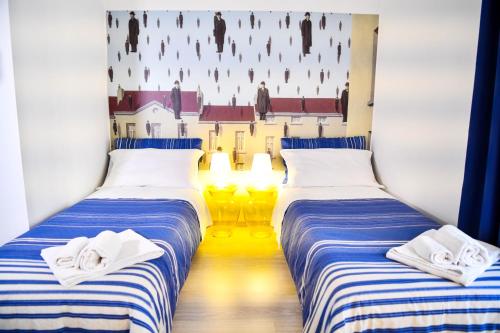 two beds in a room with blue and white stripes at Camere D'artista in Enna
