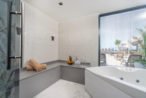 baño blanco con bañera y ventana en Simus Beach Hotel, en Side