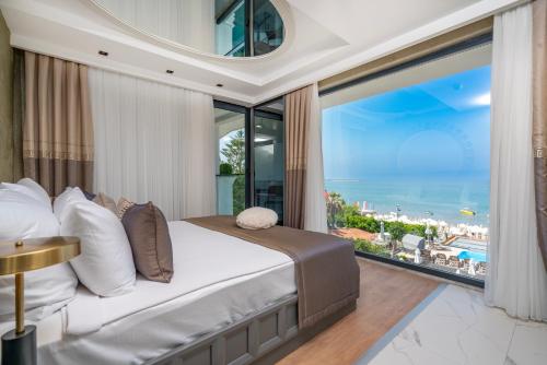 a bedroom with a bed and a large window at Simus Beach Hotel in Side