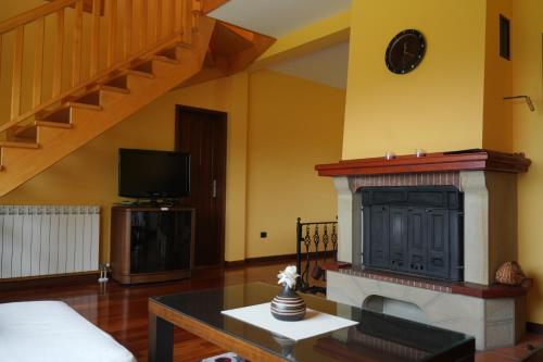 a living room with a fireplace and a tv at Vila Zeleno borje in Žabljak