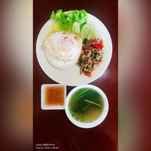 a table with two plates of food and a bowl of soup at Ditar Guest House D in Battambang