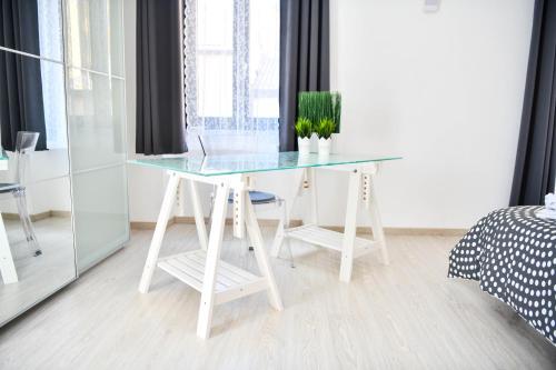 a white desk with a glass top in a bedroom at Camere D'artista in Enna
