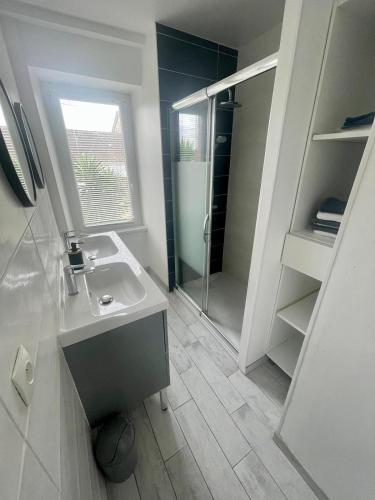 une salle de bain avec un lavabo et une douche dans l'établissement Maison de vacances 5 voyageurs, à Cherbourg en Cotentin