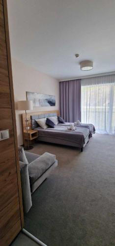 シェンナにあるApartament Czarna Góra STARのベッドルーム(ベッド3台、ソファ付)