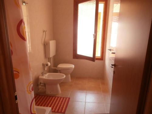 a bathroom with a toilet and a window at B&B Neverland in Marrùbiu
