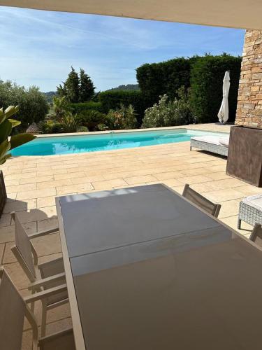 un patio avec une table et des chaises et une piscine dans l'établissement Appartement de prestige avec piscine, à Laouque