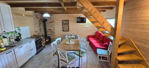 a living room with a table and a red couch at Kaszuby wczasy u Danusi sauna i bania in Lipusz