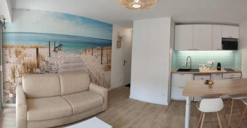 a living room with a couch and a beach mural at Charmant appartement T2 - Proposition de séjours avec des activités locales - 200m de la plage avec jardin et terrasse- RDC in Carnac