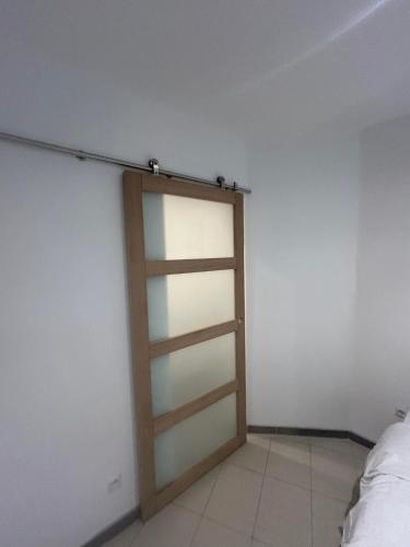 Cette chambre comprend une porte coulissante en verre. dans l'établissement TOP appartement centre ville, à Valenciennes