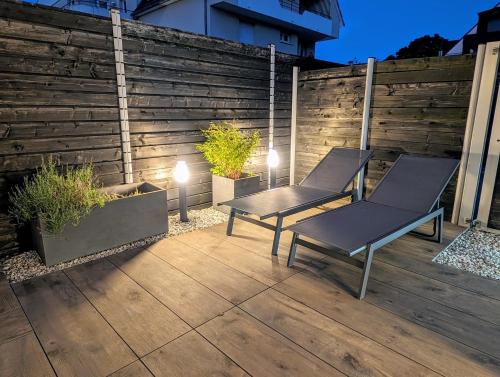 two benches sitting on a patio with lights at La Chataigneraie in Châtenois