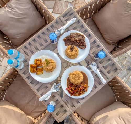 una mesa con tres platos de comida. en Villa Khufu Pyramids Inn en El Cairo