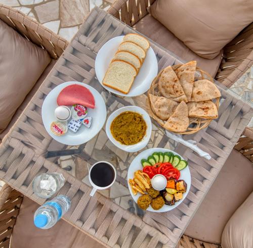 a table with plates of food and bread and dips at Villa Khufu Pyramids Hotel in Cairo