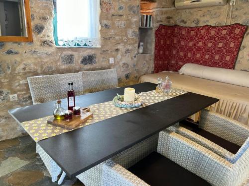 un tavolo con una bottiglia di vino e due bicchieri di Guesthouse Kamara II a Monemvasía