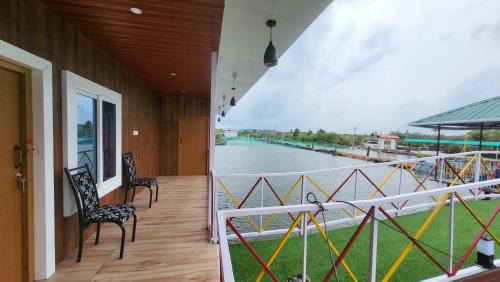 a balcony with chairs and a view of the water at Bell Farms and Resorts in Munroe Island