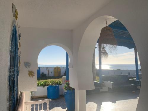 an archway in a building with a view of the ocean at Villa Acqua en front de mer in Nabeul
