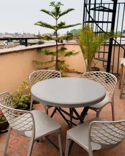 ein weißer Tisch und Stühle auf einem Balkon in der Unterkunft Laxmi Niwas in Pātan