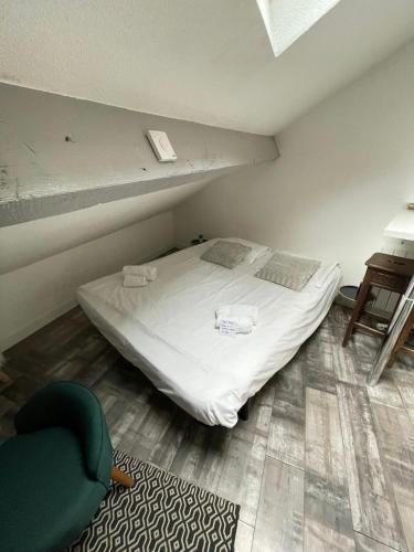 - une chambre avec un lit et une chaise verte dans l'établissement Grenier du Lac 100 m du lac, à Annecy