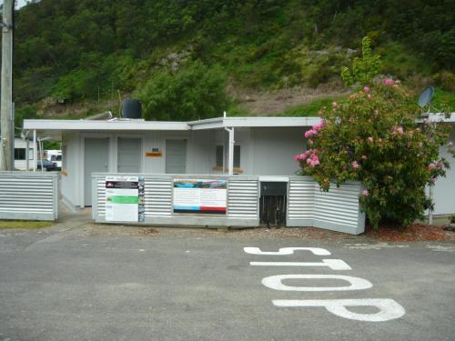 ein weißes Gebäude mit einem Stoppschild auf einem Parkplatz in der Unterkunft Alexanders Holiday Park in Picton