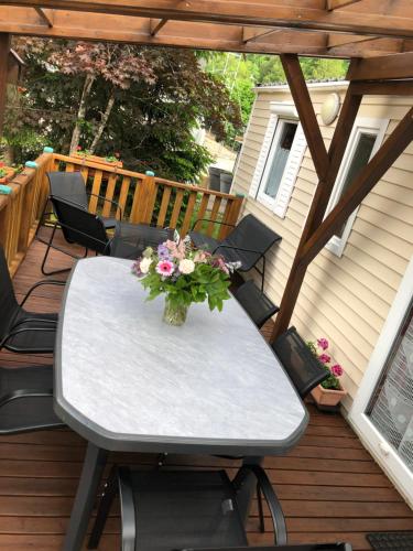 une table avec un vase de fleurs sur une terrasse dans l'établissement mobil home 6 personnes a SAMOENS, à Samoëns