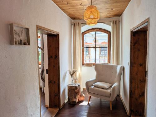 a living room with a chair and a window at Neu! Moderner bayrischer Flair vor Pilatushaus in Oberammergau