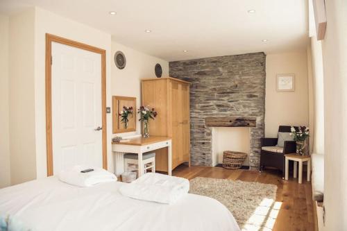 a bedroom with a bed and a stone wall at Dukes House - first floor apartment in Padstow