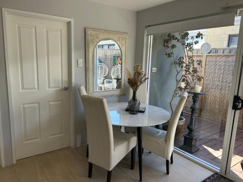 a dining room with a table and chairs and a mirror at Whitfords Delight Bed & Breakfast in Perth