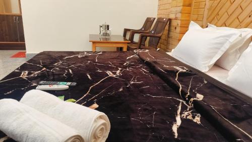 a bed in a room with a table and chairs at Kavyansh Forest Valley in Dalhousie