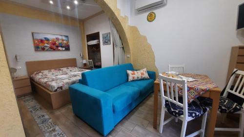 een woonkamer met een blauwe bank en een bed bij Il Sole della Guilla in Palermo