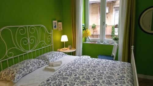zieloną sypialnię z łóżkiem i oknem w obiekcie B&B Stella Scugnizza w mieście Napoli
